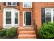 Close-up of a home's brick front porch with a black front door and sidelight window at 1885 Oak Wind Ln, Buford, GA 30519