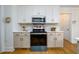 Kitchen showcasing stainless steel appliances, white cabinets, and a neutral backsplash at 1885 Oak Wind Ln, Buford, GA 30519