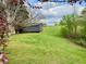 Landscaped backyard featuring a storage shed, with mature trees and greenery providing a peaceful setting at 2210 Holly Springs Rd, Rockmart, GA 30153