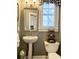Powder room features a pedestal sink, modern toilet, and a window with wood shutters at 2210 Holly Springs Rd, Rockmart, GA 30153