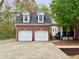 Two-car garage with white doors and a brick facade, offering ample parking at 2210 Holly Springs Rd, Rockmart, GA 30153