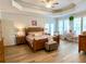 Bright main bedroom with tray ceiling, wooden furniture, and an ensuite bathroom at 2210 Holly Springs Rd, Rockmart, GA 30153