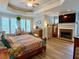 Main bedroom with fireplace, tray ceiling, and large windows at 2210 Holly Springs Rd, Rockmart, GA 30153