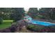 Aerial view of outdoor pool and gazebo, surrounded by colorful landscaping and a wooded area at 2210 Holly Springs Rd, Rockmart, GA 30153