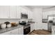 Modern kitchen with stainless steel appliances, granite countertops, and white cabinets offers a clean aesthetic at 232 Paisley Way, Locust Grove, GA 30248