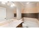 Bright bathroom featuring a combo tub/shower with brown accent tiles and a large mirror at 4002 Moheb Sw St, Atlanta, GA 30331