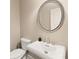 Powder room featuring a pedestal sink, round mirror and toilet at 4002 Moheb Sw St, Atlanta, GA 30331