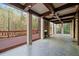 Spacious covered deck featuring ceiling fans, stone fireplace, and beautiful wooded backyard views at 4002 Moheb Sw St, Atlanta, GA 30331