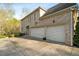 Spacious two-car garage with extra parking space, charming exterior sconces, and a wooded landscape at 4002 Moheb Sw St, Atlanta, GA 30331
