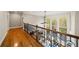 Upstairs hallway with wood floors, decorative railing, and windows overlooking the deck at 4002 Moheb Sw St, Atlanta, GA 30331