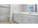Bathroom featuring double vanity with white cabinetry, tile floors and a view of the shower/tub at 4522 Willow Oak Trl, Powder Springs, GA 30127