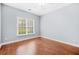 Bedroom with a window overlooking a yard, showcasing hardwood floors and neutral walls at 4522 Willow Oak Trl, Powder Springs, GA 30127