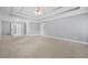 Spacious bedroom with tray ceilings, carpet flooring, and an ensuite bathroom entrance at 4522 Willow Oak Trl, Powder Springs, GA 30127