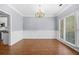 Empty dining room featuring hardwood floors, paneled walls, a window, and a chandelier at 4522 Willow Oak Trl, Powder Springs, GA 30127