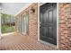 Close-up of brick front porch with classic black front door and decorative shuttered windows at 4522 Willow Oak Trl, Powder Springs, GA 30127