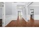 Inviting hallway with hardwood floors, decorative trim, and view of the kitchen at 4522 Willow Oak Trl, Powder Springs, GA 30127