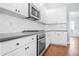The kitchen has white cabinets, granite countertops, and stainless steel appliances at 4522 Willow Oak Trl, Powder Springs, GA 30127