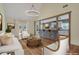 Bright living room with hardwood floors, white sofas, and an open layout to the kitchen at 475 Brown Thrasher Ct, Alpharetta, GA 30009