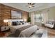 Spacious main bedroom with wood accent wall, tray ceilings, and a large window providing ample natural light at 475 Brown Thrasher Ct, Alpharetta, GA 30009
