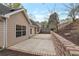 The backyard patio features a brick retaining wall, a spacious patio, and mature trees at 475 Brown Thrasher Ct, Alpharetta, GA 30009