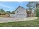 Exterior of home featuring a two-car garage, screened in porch, and a large yard at 60 Riverside Pkwy, Sharpsburg, GA 30277