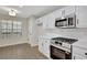 Bright eat-in kitchen showcasing stainless steel appliances, white cabinets and hardwood flooring at 60 Riverside Pkwy, Sharpsburg, GA 30277