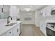 Well-lit kitchen featuring white cabinets, stainless steel appliances, and hardwood flooring at 60 Riverside Pkwy, Sharpsburg, GA 30277