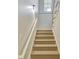 Carpeted staircase with a white handrail leading upstairs, bathed in natural light at 60 Riverside Pkwy, Sharpsburg, GA 30277