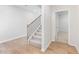 Welcoming hallway featuring light wood flooring, staircase with black metal spindles, and an open doorway at 7182 Brushwood Bend (Lot 114), Lithonia, GA 30058
