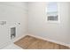 Functional laundry room with wood-look flooring, utility connections, and a window at 7182 Brushwood Bend (Lot 114), Lithonia, GA 30058
