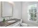 Elegant bathroom with an ornate mirror, marble countertop, and a window offering natural light at 2281 Bransley Pl, Duluth, GA 30097