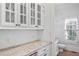 Butler pantry with granite countertop, white cabinets and drawers, glass front upper cabinets, and convenient beverage refrigerator at 2281 Bransley Pl, Duluth, GA 30097