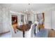 Elegant dining room with hardwood floors, decorative wallpaper, and a classic chandelier at 2281 Bransley Pl, Duluth, GA 30097