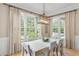 Bright dining room with hardwood floors, wainscoting, large windows, and elegant chandelier lighting at 2281 Bransley Pl, Duluth, GA 30097