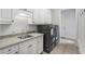 Well-equipped laundry room with a stainless steel sink, modern washer and dryer, and ample counter and cabinet space at 2281 Bransley Pl, Duluth, GA 30097