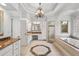 Elegant main bathroom includes a chandelier, double vanity, soaking tub, tiled shower, and marble countertops at 2281 Bransley Pl, Duluth, GA 30097