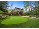 Expansive backyard with putting green, tiered landscaping, and an inviting pool area for outdoor enjoyment at 4688 Oakleigh Manor Dr, Powder Springs, GA 30127