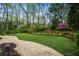 An expansive backyard with putting green, stone retaining wall and many mature trees at 4688 Oakleigh Manor Dr, Powder Springs, GA 30127
