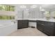 A bright bathroom features dual sinks, ample counter space, stylish dark cabinetry, and a soaking tub under a large window at 4688 Oakleigh Manor Dr, Powder Springs, GA 30127
