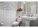Chic powder room with floral wallpaper, stylish mirror, and pedestal sink at 4688 Oakleigh Manor Dr, Powder Springs, GA 30127