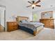 Sunlit bedroom with wooden furniture sets and plush carpeting, complemented by ceiling fan and natural light from window at 4688 Oakleigh Manor Dr, Powder Springs, GA 30127