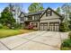 Charming two-story home with a well-manicured lawn, mature trees, and a three-car garage at 4688 Oakleigh Manor Dr, Powder Springs, GA 30127