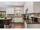 Well-designed kitchen featuring white cabinetry, tile backsplash, granite countertops, and stainless steel appliances at 4688 Oakleigh Manor Dr, Powder Springs, GA 30127