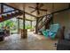 A covered outdoor living space featuring a ceiling fan, swing and view of the home's landscaped yard at 4688 Oakleigh Manor Dr, Powder Springs, GA 30127