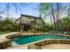 A beautiful pool area with stone trim, palm tree, a deck and stairs to a second story porch at 4688 Oakleigh Manor Dr, Powder Springs, GA 30127