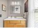 Bright bathroom featuring a wooden vanity with a white countertop and decorative mirror at 6585 Queen Mill Se Rd, Mableton, GA 30126