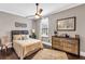 Neutral bedroom with a ceiling fan, hardwood floors, and a bed with a cushioned headboard at 6585 Queen Mill Se Rd, Mableton, GA 30126