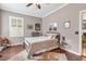 Comfortable bedroom featuring a ceiling fan, neutral walls, hard wood floors, and decoratively arranged pillows at 6585 Queen Mill Se Rd, Mableton, GA 30126