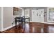 Inviting dining area with hardwood floors, a dark wood table, and charming front door at 6585 Queen Mill Se Rd, Mableton, GA 30126