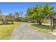 View of the long driveway leading to a gray home with a spacious yard and mature landscaping at 6585 Queen Mill Se Rd, Mableton, GA 30126